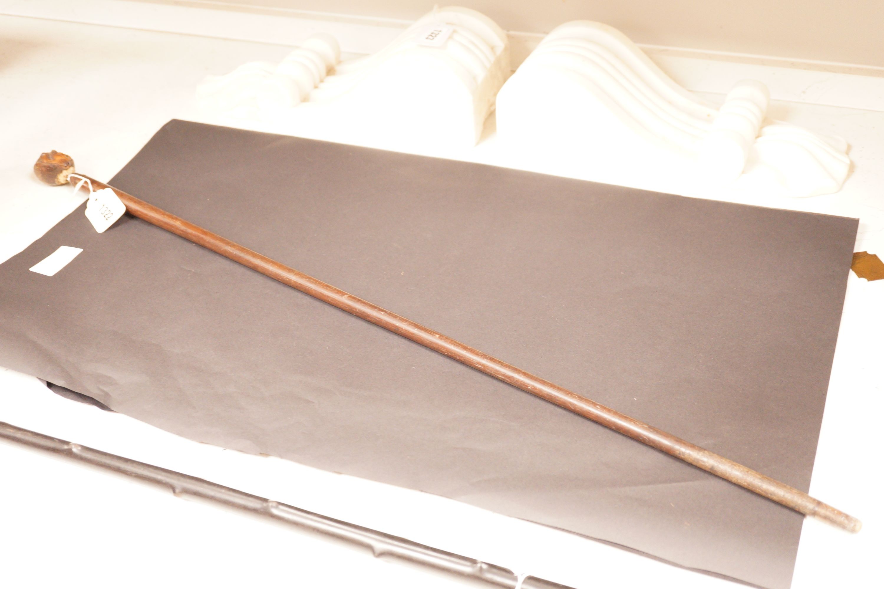 A 19th century continental carved head with glass eyes on associated cane stick. Total length 92cm